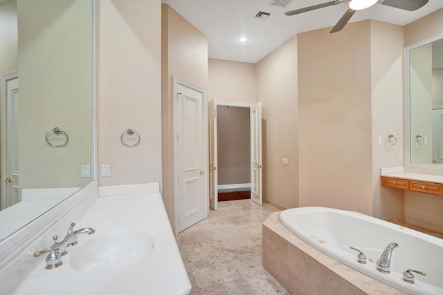 bathroom with tiled bath, ceiling fan, and vanity