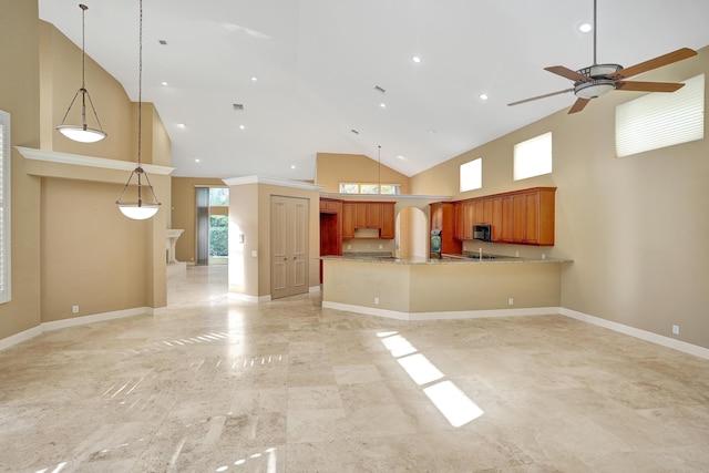 unfurnished living room with a towering ceiling and ceiling fan