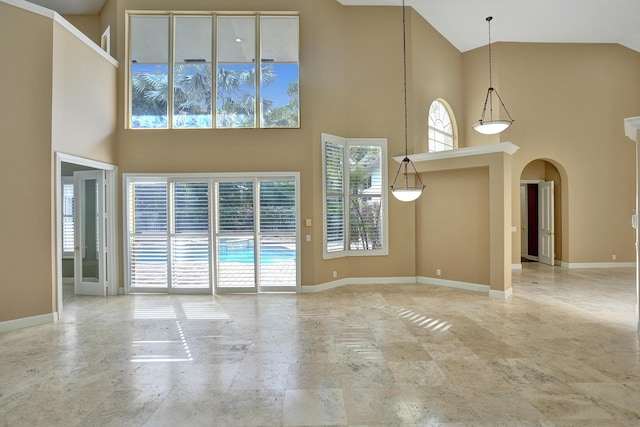 unfurnished living room with a towering ceiling