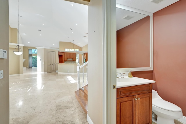 bathroom featuring ornamental molding, vanity, toilet, and lofted ceiling