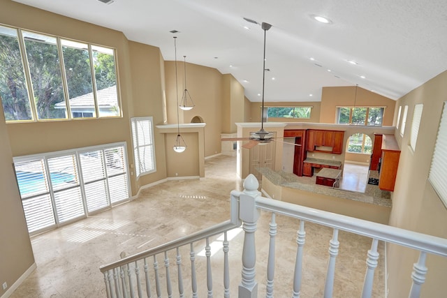 staircase featuring ceiling fan and high vaulted ceiling