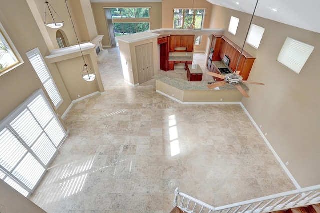 interior space with ceiling fan and a high ceiling