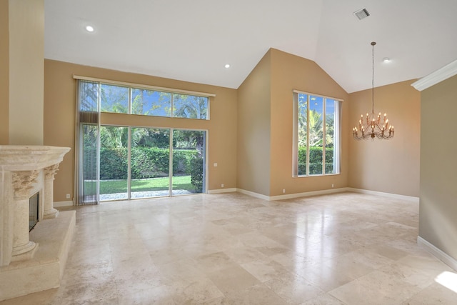 unfurnished living room with a fireplace, high vaulted ceiling, and a notable chandelier