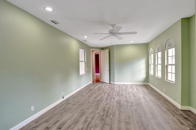 spare room with a textured ceiling, light hardwood / wood-style floors, and ceiling fan