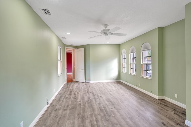 unfurnished room with ceiling fan, light hardwood / wood-style floors, and a textured ceiling