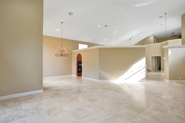 spare room featuring a high ceiling and an inviting chandelier