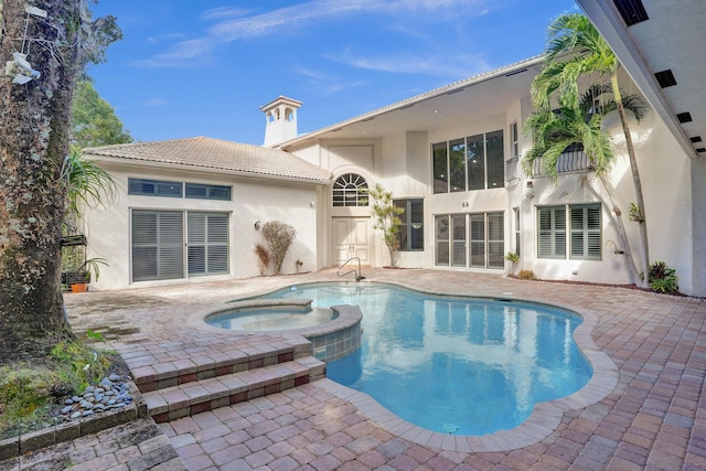 view of pool with an in ground hot tub and a patio area