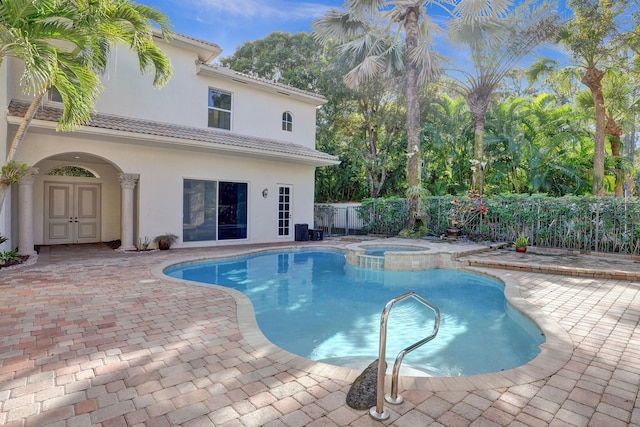 view of pool with an in ground hot tub and a patio