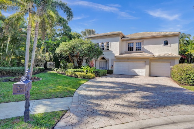 mediterranean / spanish-style home with a garage and a front lawn