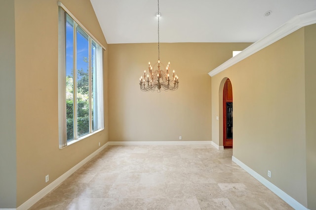 spare room with crown molding and a chandelier