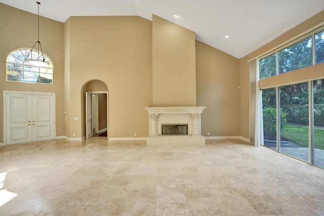 unfurnished living room with a high end fireplace and a high ceiling