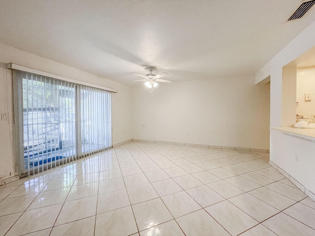 tiled empty room featuring ceiling fan