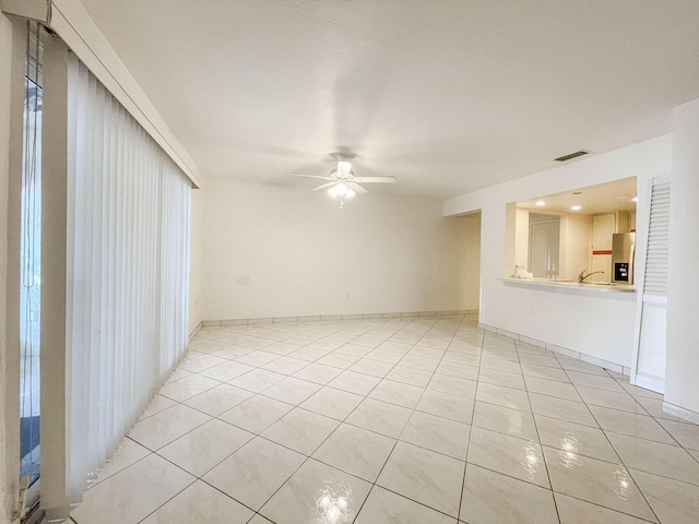 unfurnished room with light tile patterned floors and ceiling fan