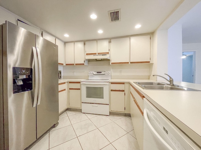 kitchen with sink, light tile patterned floors, and white appliances