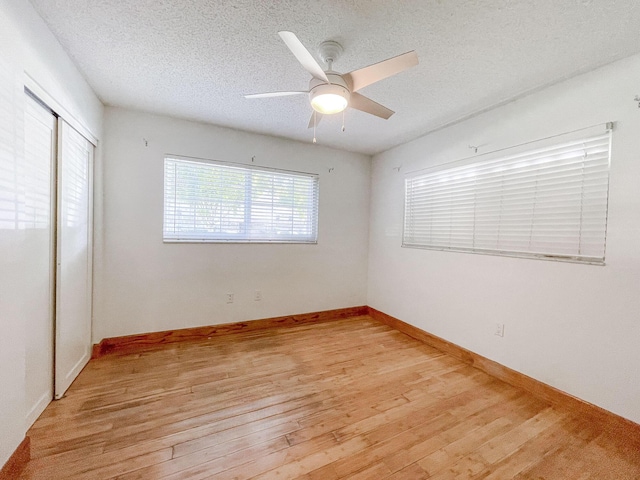 spare room featuring ceiling fan, light hardwood / wood-style floors, and a textured ceiling