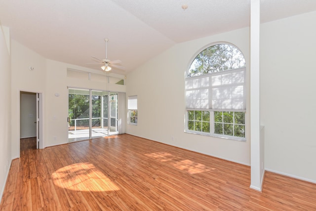 unfurnished living room featuring light wood-type flooring, vaulted ceiling, and ceiling fan