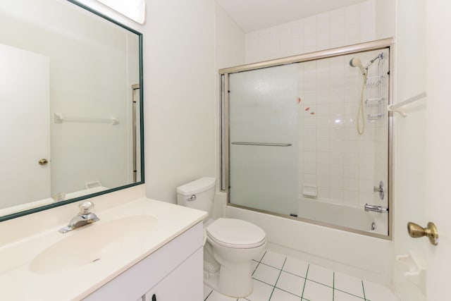 full bathroom with combined bath / shower with glass door, vanity, tile patterned flooring, and toilet