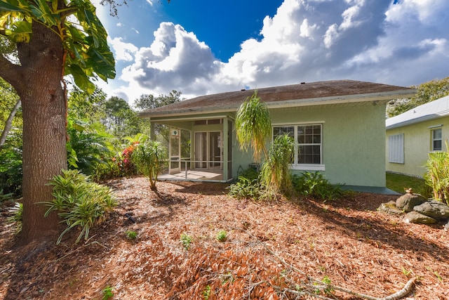 back of property with a sunroom