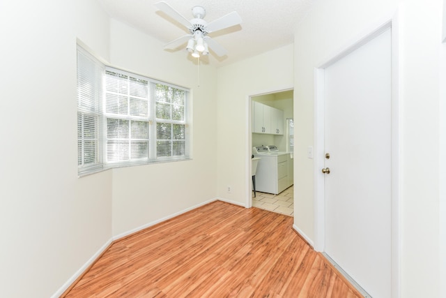 unfurnished room with light hardwood / wood-style flooring, ceiling fan, and washing machine and clothes dryer