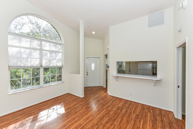 unfurnished living room with hardwood / wood-style flooring and a wealth of natural light