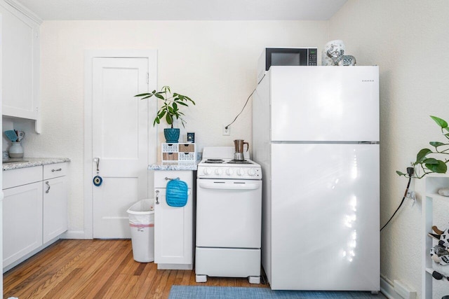 kitchen featuring white cabinets, white appliances, and light hardwood / wood-style flooring