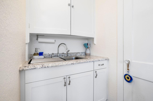 kitchen featuring white cabinets and sink