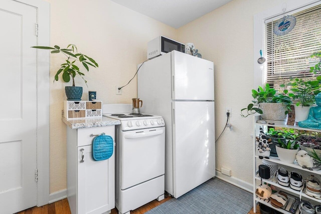 kitchen featuring light hardwood / wood-style floors and white appliances