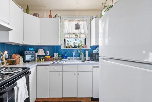 kitchen featuring tasteful backsplash, white cabinetry, sink, and white appliances