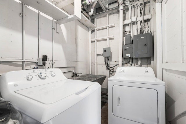 laundry room featuring electric panel, washer and clothes dryer, and sink