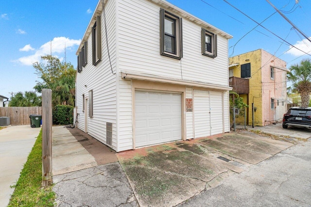 view of side of property featuring a garage and cooling unit