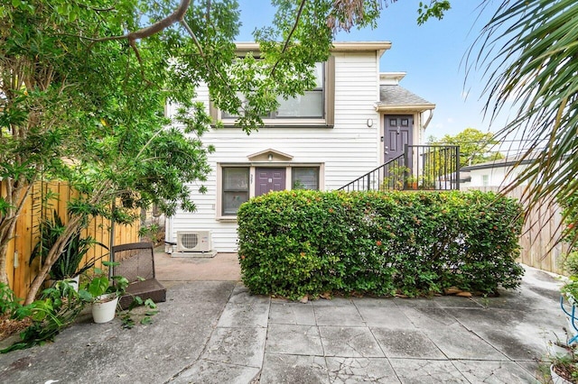 view of front of home with ac unit and a patio