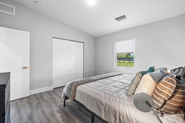 bedroom featuring a closet, wood-type flooring, and vaulted ceiling