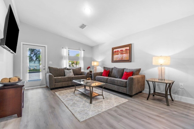 living room featuring light hardwood / wood-style flooring and lofted ceiling