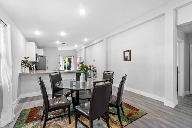 dining space featuring light wood-type flooring and sink