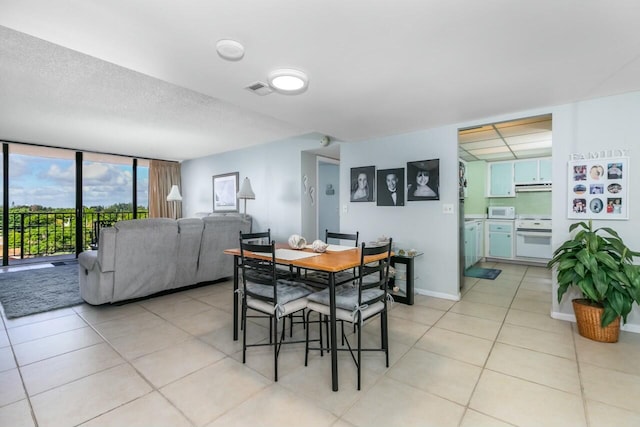 tiled dining space featuring expansive windows and a textured ceiling