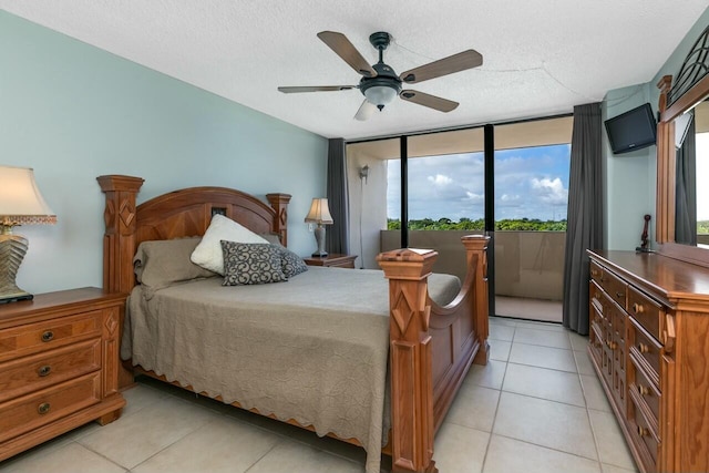 bedroom with ceiling fan, light tile patterned flooring, and a textured ceiling