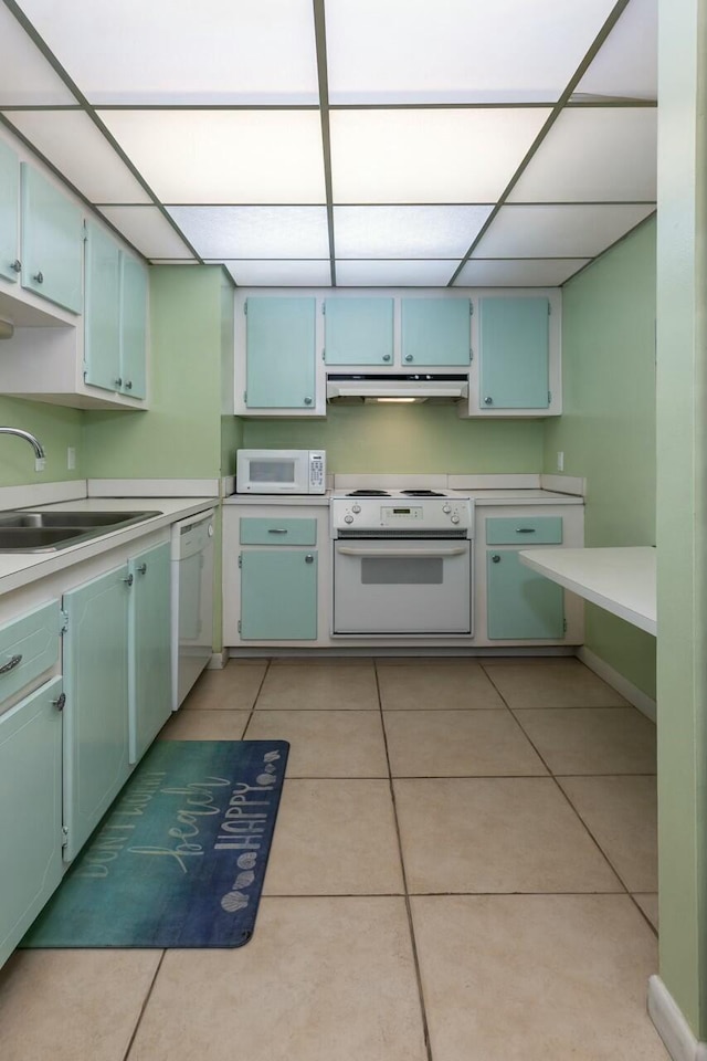 kitchen with white appliances, sink, and light tile patterned floors