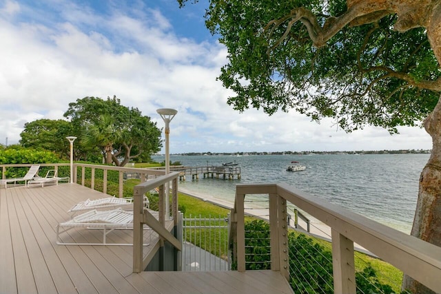 wooden deck with a dock and a water view