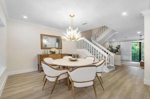 dining area with light hardwood / wood-style floors, ornamental molding, and a chandelier