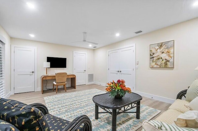 living room featuring light wood-type flooring and ceiling fan