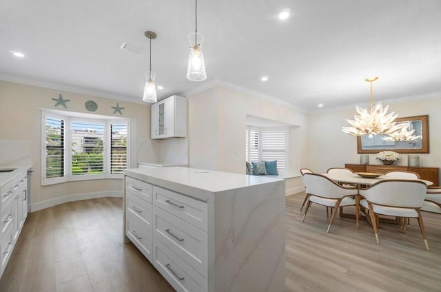 kitchen with white cabinetry, light wood-type flooring, decorative light fixtures, and an inviting chandelier