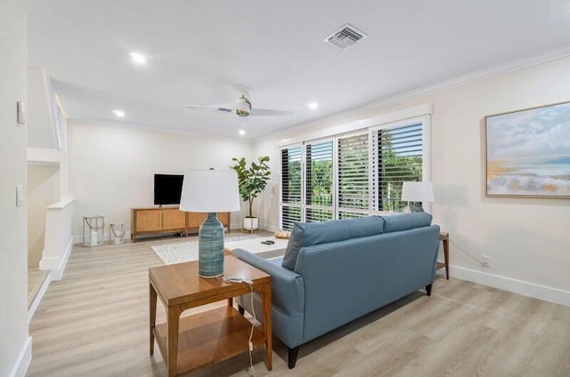 living room with light wood-type flooring, ceiling fan, and crown molding