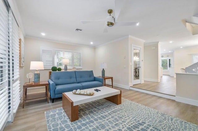 living room with ceiling fan, ornamental molding, a wealth of natural light, and light hardwood / wood-style flooring