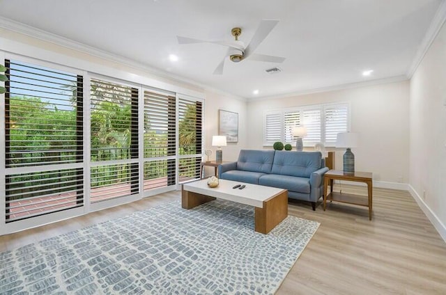 living room with light wood-type flooring, ceiling fan, and ornamental molding