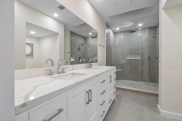 bathroom with a shower with door, vanity, and tile patterned flooring