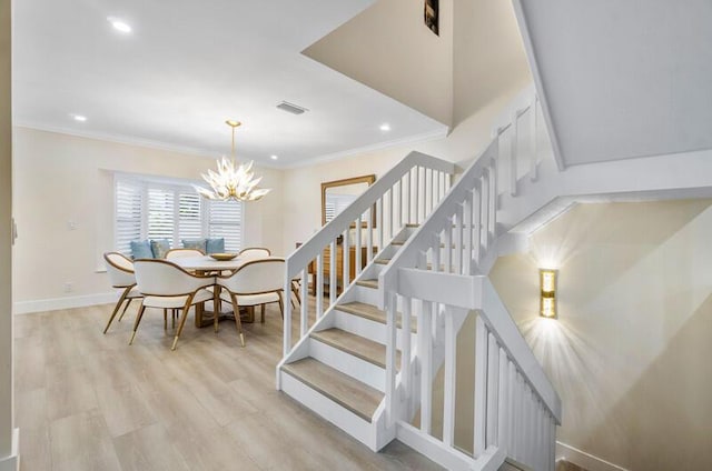 dining room featuring light hardwood / wood-style flooring, a notable chandelier, and crown molding