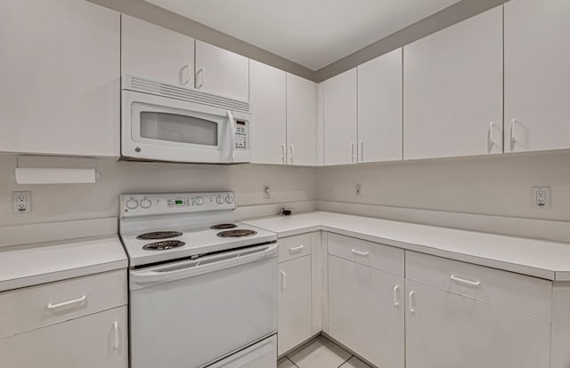 kitchen featuring white cabinetry, light tile patterned floors, and white appliances