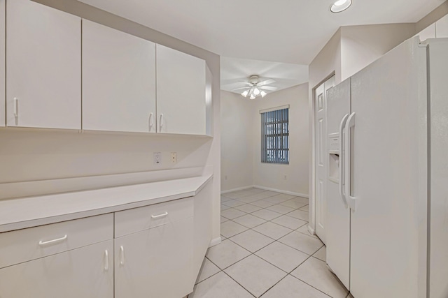 kitchen with light tile patterned flooring, white refrigerator with ice dispenser, white cabinets, and ceiling fan