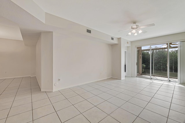 tiled spare room featuring ceiling fan