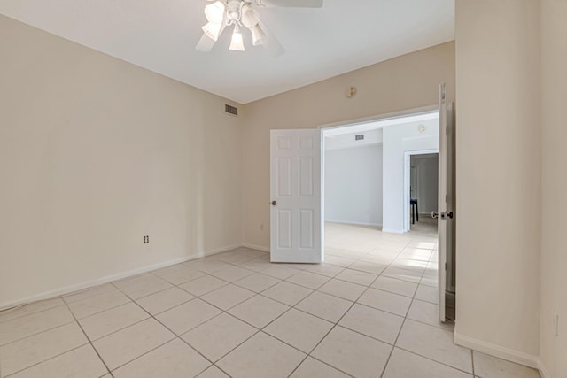 spare room with ceiling fan and light tile patterned flooring